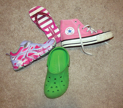 Five children's shoes arranged in a wheel-spoke pattern