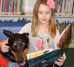 A child reads to a canine friend at Lewiston (NY) Public Library.