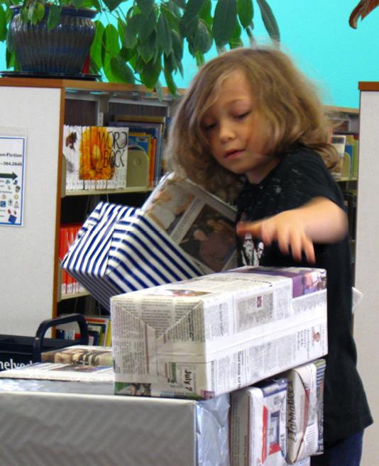 Playing giant Jenga made using twelve-pack soda boxes