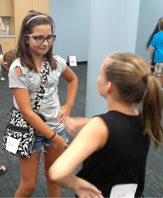 Fifth-year camper Bella, facing, practices mirroring techniques with veteran camper Lanie