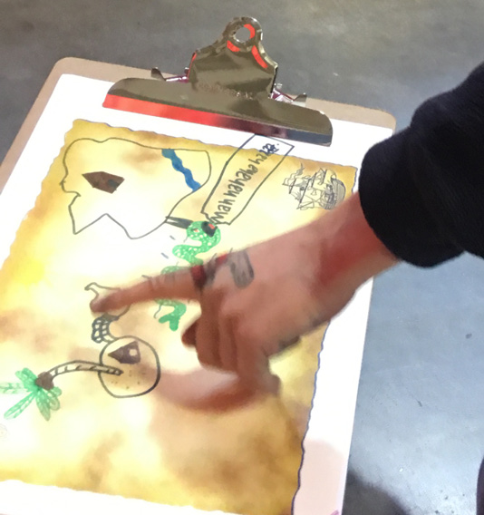 A person pointing to an aspect of a hand-drawn map