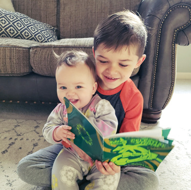 Max may be too little to read, but he loves sharing a book with his new baby sister, Harper.