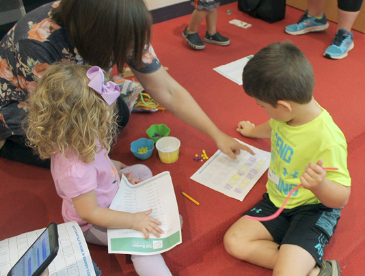 Preschoolers practice binary coding by making bracelets with their coded initials (photo by Debbie Roycroft, KidSpace staff member at GBPL).