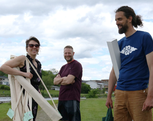 Jenn, left, carries the kites in their quivers while a patron and Leland, right, prepare for an afternoon of flying.