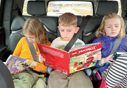 Children reading in the back seat of a car