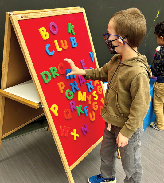 A child spells using madnet letters