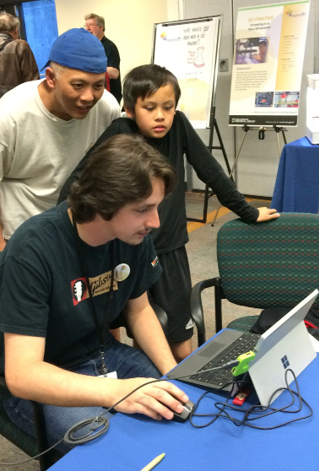Figure 5. A library staff member works with a father and son at our inaugural Imagine IT technology fair