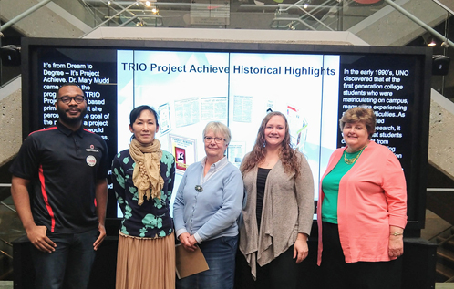 Figure 14. Former UNO Libraries Digital Initiatives Librarian Yumi Ohira with TRiO Project Achieve staff standing in front of the Project Achieve Historical Highlights digital exhibit. From left: Director Shannon Teamer, Yumi Ohira, English Specialist Connie Sorensen-Birk, Office Associate Lauren Wyler, Counselor Pat-Killeen-Brown.